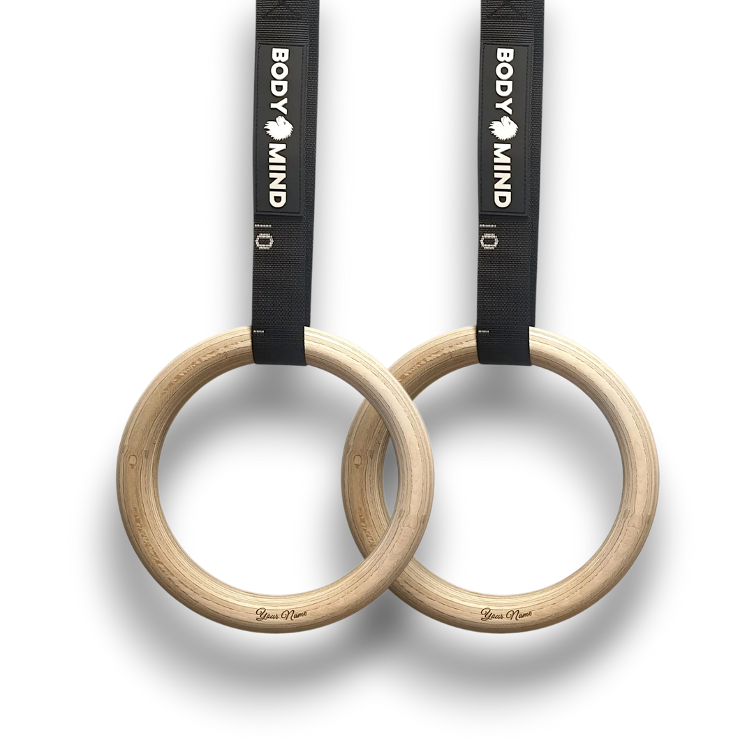 Personalized wooden gymnastic rings with black straps.