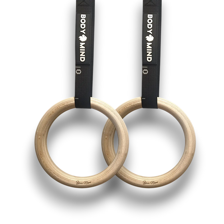 Personalized wooden gymnastic rings with black straps.